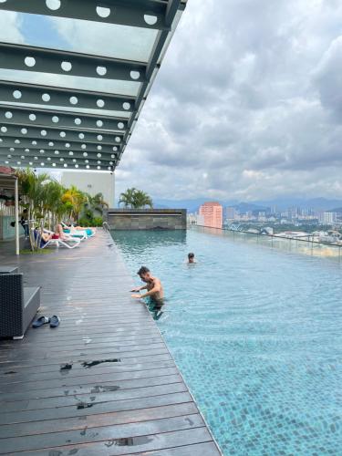 two people in a swimming pool on top of a building at Regalia Spritz Empire Hostel in Kuala Lumpur