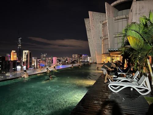 a swimming pool with a city skyline at night at Regalia Spritz Empire Hostel in Kuala Lumpur