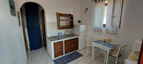 una pequeña cocina con fregadero y nevera. en Case Vacanze Marina Longo, en Santa Marina Salina