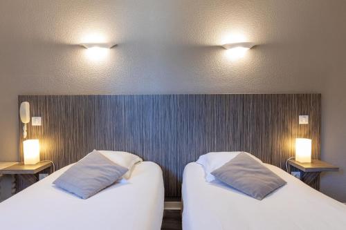 Una cama o camas en una habitación de Hôtel Café les Fleurs