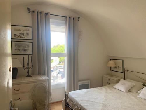 une chambre avec un lit blanc et une fenêtre dans l'établissement GRUISSAN PORT JOLI T3 DUPLEX, à Gruissan