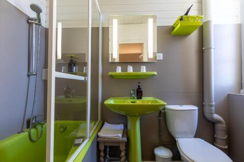 a bathroom with a green sink and a toilet at Hôtel Café les Fleurs in Argelès-Gazost