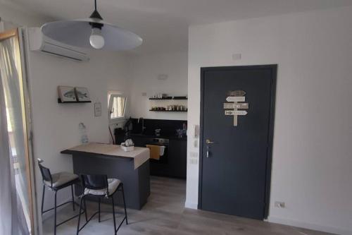 a kitchen with a black door and a table and chairs at Casa BLU B7 4 in La Maddalena