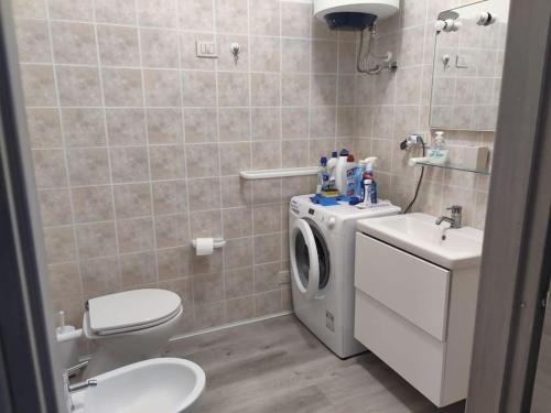 a bathroom with a washing machine and a sink at Casa BLU B7 4 in La Maddalena