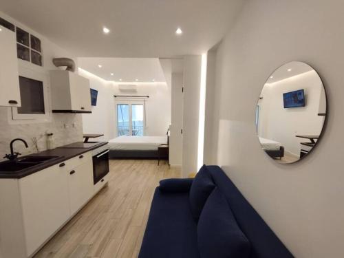 - une cuisine et un salon avec un canapé bleu et un miroir dans l'établissement Minimal Athens Apartment, à Athènes