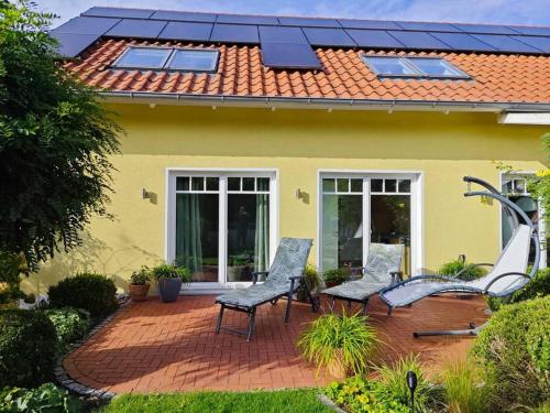 a house with two chairs on a brick patio at FeWo Hope in Lindwedel