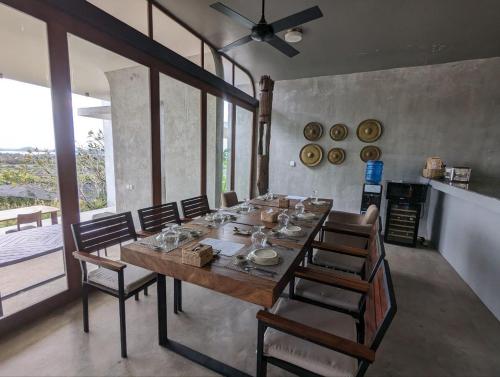 a dining room with a long table and chairs at Villa La Plantation in Kampot