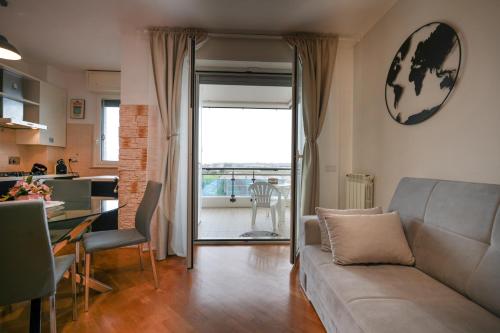 a living room with a couch and a table and a kitchen at Nuvola Apartment Fiumicino Easy Self check-in in Fiumicino