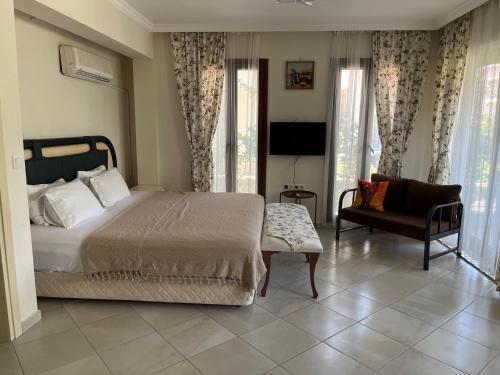 um quarto com uma cama, um sofá e uma cadeira em Grand Teoshan Otel ve Tatil Evleri em Seferihisar