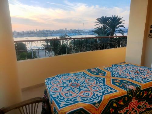 a balcony with a table and a view of a river at Top View in Luxor