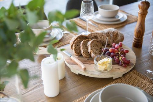 una mesa de madera con un plato de pan y uvas en Sea View Guest House en Hobart