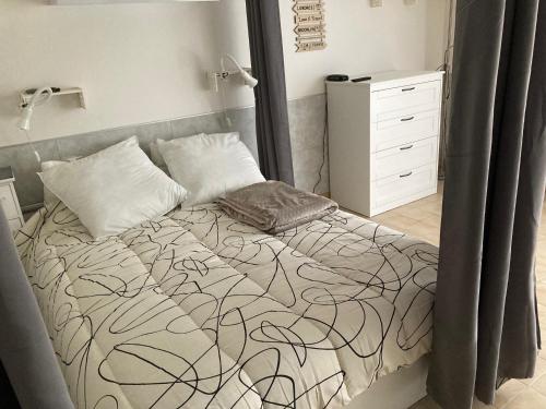 a bedroom with a bed with a black and white blanket at Le Beaulieu appartement T1 Bis RDC classé 3 étoiles avec parking à Barbotan in Cazaubon