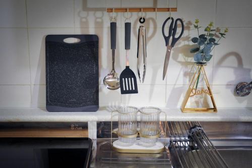 um balcão de cozinha com dois copos e facas e utensílios em QQQ 3room spacious house at Jamsil em Seul