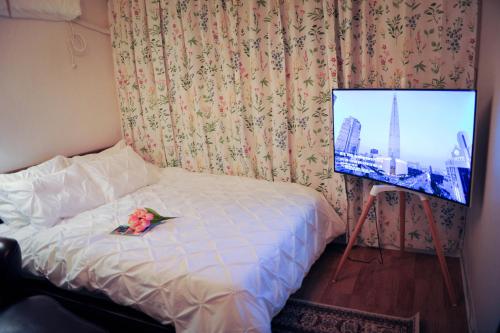 um quarto com uma cama e uma televisão com uma flor em QQQ 3room spacious house at Jamsil em Seul