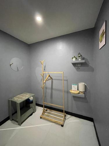 a room with a gray wall with a bench and a shelf at Mantilla Hostel in Coron