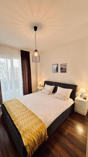 a bedroom with a large bed with a yellow blanket at Bonjour Residence with terrace and parking in Cluj-Napoca