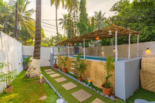 a backyard with a swimming pool and a pavilion at Ekostay - OCEAN CREST VILLA I 50 meters from Anjuna Beach in Vagator