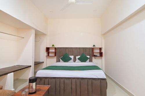 a bedroom with a large bed with green pillows at Chowdhry Tourist Lodge - New Delhi Railway Station - 2 minutes walk in New Delhi