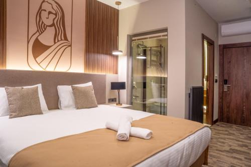 a bedroom with a bed with a towel on it at MONALİSA HOTELS ÇANAKKALE in Hamidiye