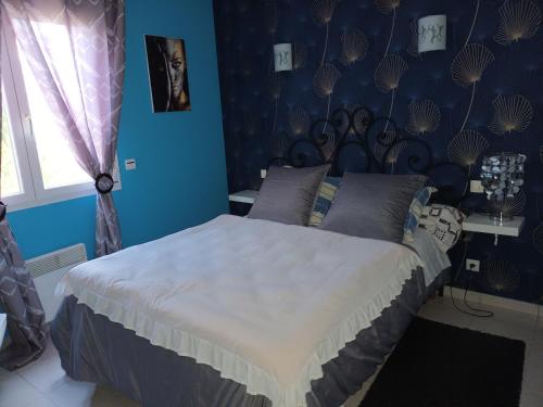 sypialnia z dużym łóżkiem z niebieskimi ścianami w obiekcie Cher Micheée et Bernard w mieście Camplong-dʼAude