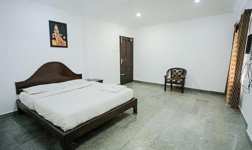 1 dormitorio con 1 cama y 1 silla en FabHotel Lime Light en Kochi