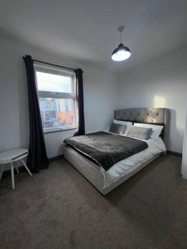 a bedroom with a large bed with a window at Modern 2 Bed Flat In Derby City in Derby