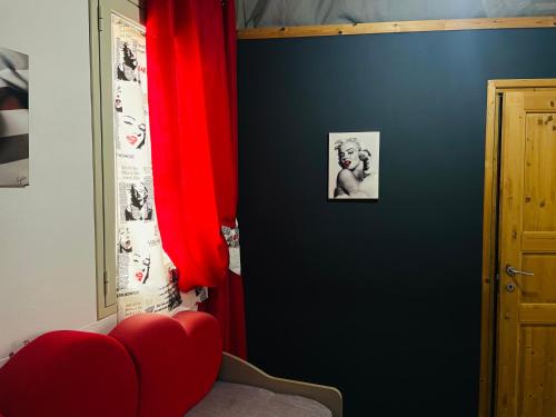 una camera con tenda rossa e sedia rossa di APPARTAMENTO Exclusive a Marsala