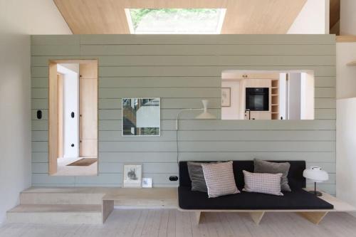 ein Wohnzimmer mit einem Sofa und einem Spiegel in der Unterkunft Urfeld26 Walchensee Berghaus mit Sauna in Urfeld