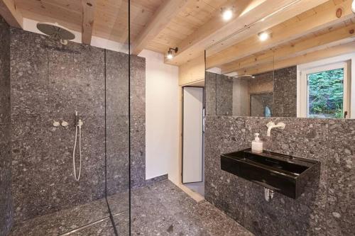 a bathroom with a glass shower with a sink at Urfeld26 Walchensee Berghaus mit Sauna in Urfeld