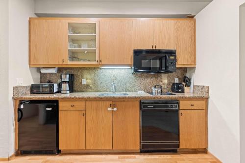 a kitchen with wooden cabinets and a black appliance at Palisades Tahoe Lodge Rentals Studio #152 in Olympic Valley