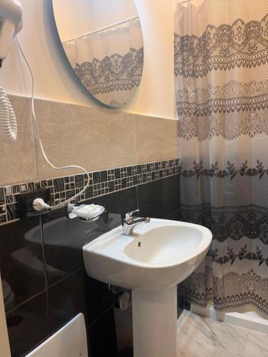uma casa de banho com um lavatório e um espelho em Oceania Hotels Napoli em Nápoles
