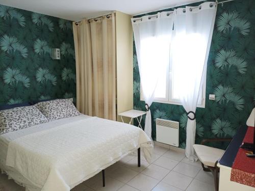 um quarto com uma cama e uma janela em Cher Micheée et Bernard em Camplong-dʼAude