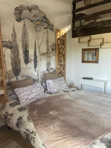 a bedroom with a large bed and a painting on the wall at Hôtel La Pinède in Saint-Marcellin-lès-Vaison