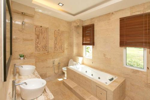 Un baño con bañera, inodoro y lavabo. en Seaview Modern 5BR Ferringhi Beach Villa 16Pax, en Batu Ferringhi