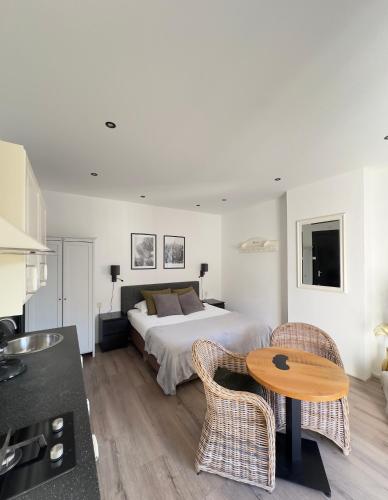 a bedroom with a bed and a table and chairs at Studio Wijkhuizen in Zandvoort