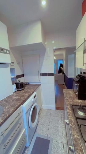 a small kitchen with a washing machine in it at Small room with double bed in Plumstead