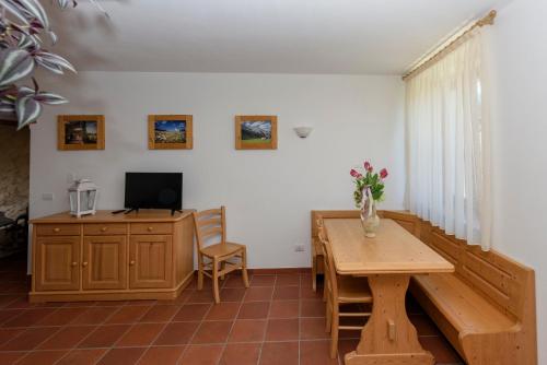 a living room with a wooden table and a desk at Agritur La Pieve in Taio