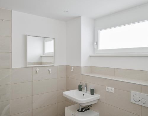 a white bathroom with a sink and a mirror at Wohnen in Wattens Top 2 in Wattens