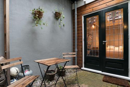 a patio with a table and benches and a door at B&B Felix in Amsterdam