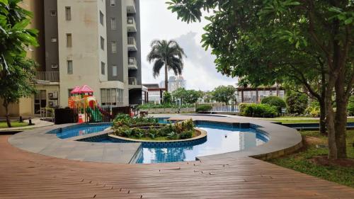a pool in the middle of a park with trees and buildings at Cozy 2 BR Apartment with pool by Ceylon Vacation in Colombo