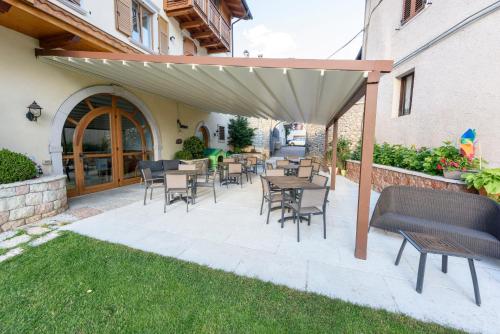 a patio with tables and chairs under an umbrella at Agritur La Pieve in Taio