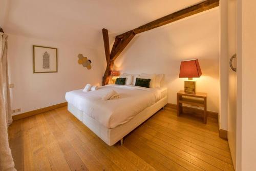Un dormitorio con una gran cama blanca y una mesa en Chic Penthouse Grand-Place en Bruselas