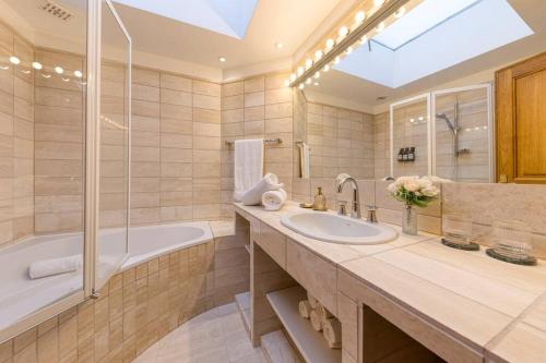 a bathroom with a sink and a tub and a shower at Chic Penthouse Grand-Place in Brussels