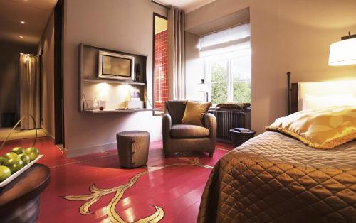 a hotel room with a bed and a chair at Ulfsunda Slott in Stockholm