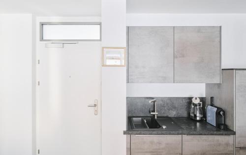 a kitchen with white cabinets and a sink at Wohnen in Wattens Top 5 in Wattens
