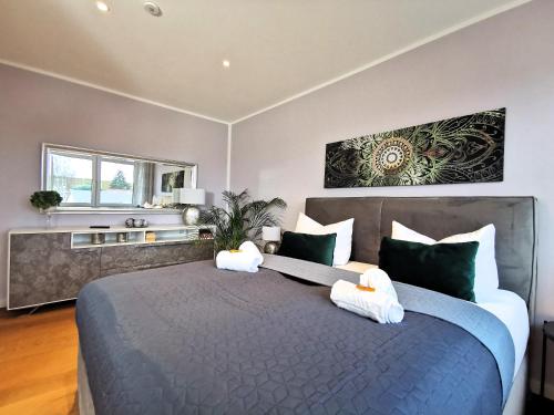 a bedroom with a large bed with green and white pillows at BohnApartments Luxury Villa Berlin - 210qm - Wintergarten - Kamin - 4 kostenlose Parkplätze - 6 Schlafzimmer - Neubau - Luxusausstattung in Birkenwerder