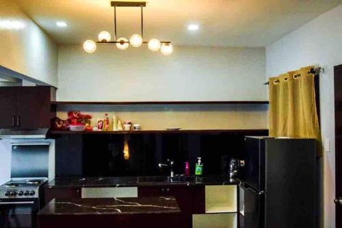 a kitchen with a black refrigerator and a sink at RQ Cozy Two Bedroom House @ La Cassandra, Wifi & Netflix in General Santos