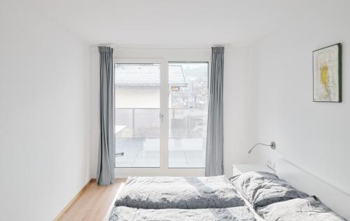 a bedroom with a bed and a large window at Wohnen in Wattens Top 5 in Wattens