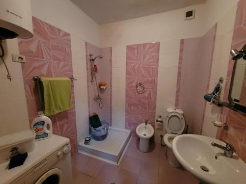 Baño de color rosa con aseo y lavamanos en Elbasan modern apartment city center, en Elbasan