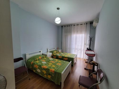 1 dormitorio con 2 camas y ventana en Elbasan modern apartment city center, en Elbasan